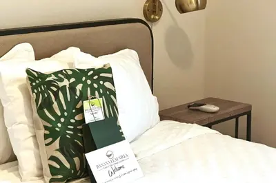 a bed with a sign on it next to a table at Banana Leaf Villa-Marley Junior Suite with Living Room in Orlando