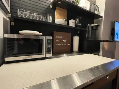 a microwave oven sitting on top of a kitchen counter at Lovely Spacious Guesthouse in Mills 50 District in Orlando