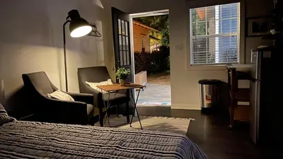 a bedroom with a bed and two chairs and a table at Lovely Spacious Guesthouse in Mills 50 District in Orlando