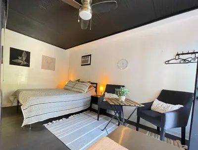 a bedroom with a bed and a table and a chair at Lovely Spacious Guesthouse in Mills 50 District in Orlando