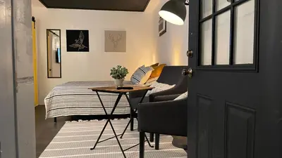 a bedroom with a bed and a table and a door at Lovely Spacious Guesthouse in Mills 50 District in Orlando