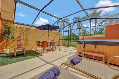 a conservatory with a table and an umbrella on a patio at Cozy townhouse in Encantada resort- 5 miles from Disney in Kissimmee