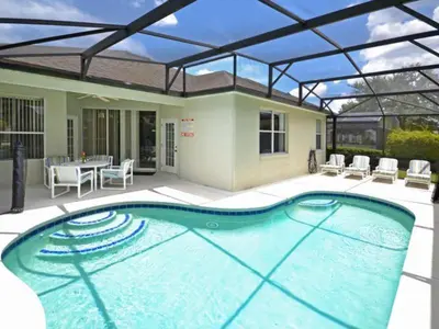 a large swimming pool with a patio with a table and chairs at Orlando Renters in Davenport