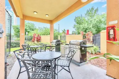 a patio with tables and chairs and a grill at Apartment w Hot Tub Pool - Near Universal Studios in Orlando