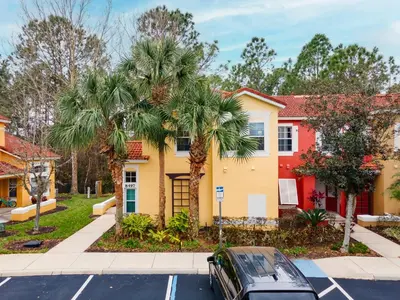 a house with palm trees in a parking lot at Natural Reserve Home at Emerald Islands in Kissimmee