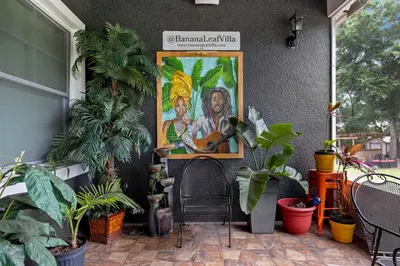 a painting of a man with a guitar on a wall at Banana Leaf Villa-Vintage Vibes- King Suite in Orlando