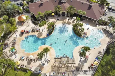 an overhead view of a large swimming pool at a resort at 3 miles to Disney, water park, kids disney rooms, pool table, air hockey, private pool and spa in Orlando