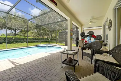 a home with a swimming pool and a patio at 3 miles to Disney, water park, kids disney rooms, pool table, air hockey, private pool and spa in Orlando