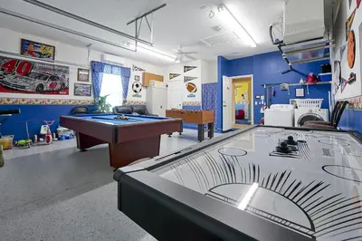 a room with a ping pong table in a room at 3 miles to Disney, water park, kids disney rooms, pool table, air hockey, private pool and spa in Orlando