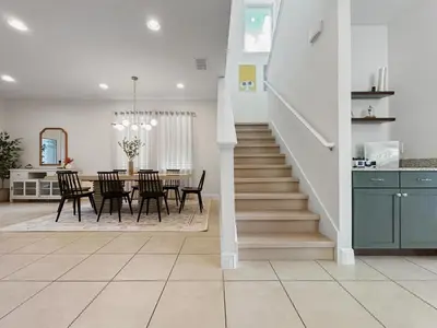 a dining room and kitchen with a staircase in a house at Luxury 5BR Villa, Pool Spa, 15min Disney in Orlando