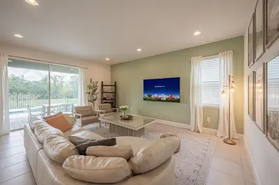 a living room with a white couch and a large window at Luxury 5BR Villa, Pool Spa, 15min Disney in Orlando