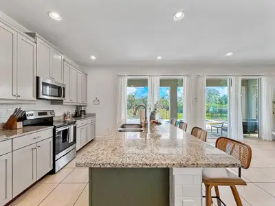a kitchen with a large island with a counter top at Luxury 5BR Villa, Pool Spa, 15min Disney in Orlando