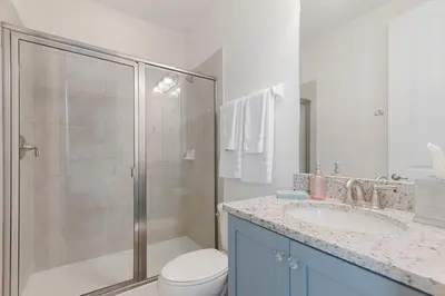 a bathroom with a shower and a toilet and a sink at Luxury 5BR Villa, Pool Spa, 15min Disney in Orlando