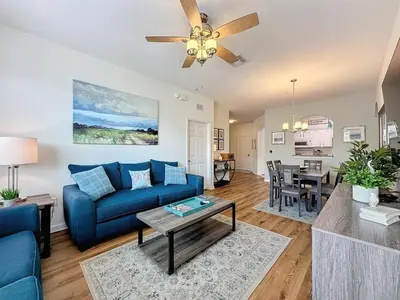 a living room with a blue couch and a table at Summer Dreams 3 Bed Condo in Windsor Hills condo in Orlando