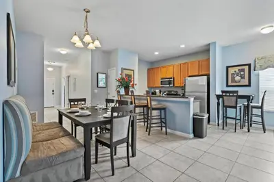 a kitchen and living room with a table and chairs at 8965 Cozy home Private Pool in Kissimmee