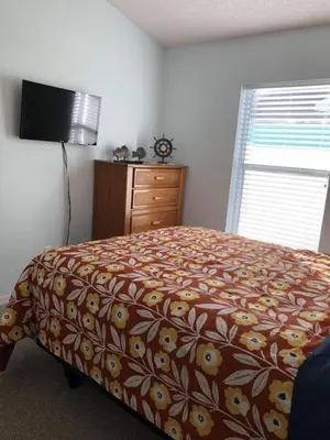 a bedroom with a bed and a dresser at Family Fun Vacation Home villa in Kissimmee