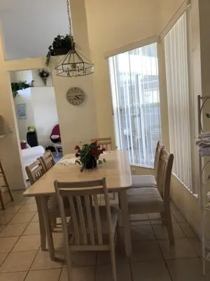 a dining room with a table and chairs and a window at Family Fun Vacation Home villa in Kissimmee