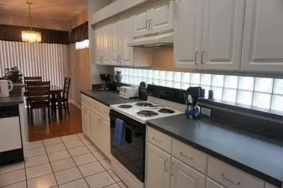 a kitchen with white cabinets and a stove top oven at Lake House near Disney in Kissimmee