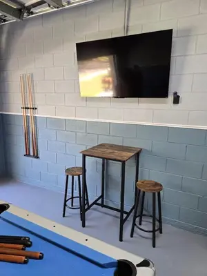 a table and two stools with a tv on a wall at Lake House near Disney in Kissimmee