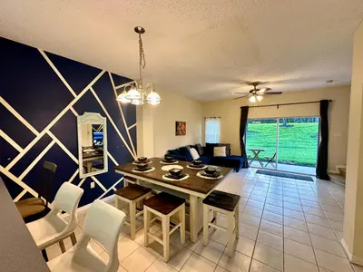 a dining room and living room with a table and chairs at Grand Deluxe 3BR Townhouse near Disney Parks in Kissimmee