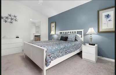 a bedroom with a white bed and a blue wall at Tropical Escape By Shine Villas 244 in Kissimmee