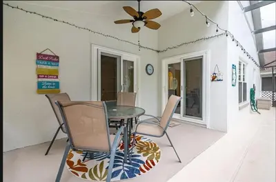 a patio with a table and chairs and a ceiling fan at Tropical Escape By Shine Villas 244 in Kissimmee
