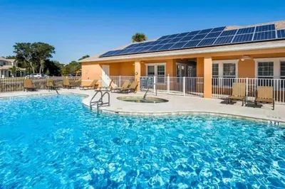 a swimming pool with solar panels on a house at Five Vacation Homes - Orlando in Orlando