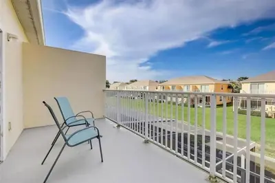 a balcony with chairs and a view of a yard at Five Vacation Homes - Orlando in Orlando