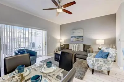 a living room with a couch and a ceiling fan at Five Vacation Homes - Orlando in Orlando