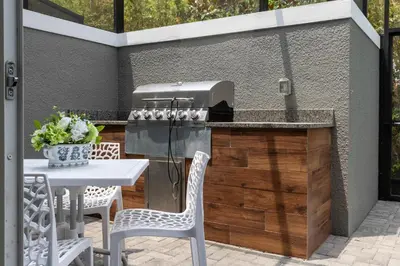 a grill on a patio with a table and chairs at Beautiful Townhome with Splash Pool near Disney 31 in Kissimmee