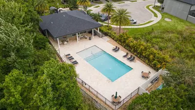 an overhead view of a swimming pool with chairs and a house at Beautiful Townhome with Splash Pool near Disney 31 in Kissimmee