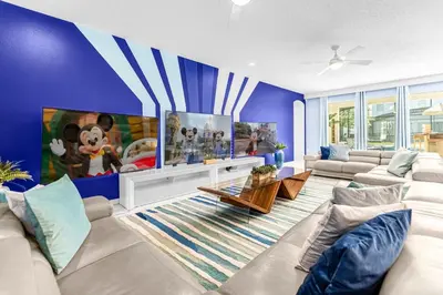 a living room with blue walls and white furniture at Upstay-Mansion w Spa-Pool-Cinema-Games - Sleeps 36 in Kissimmee