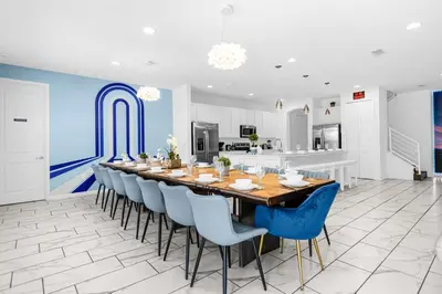 a large dining room with a long table and blue chairs at Upstay-Mansion w Spa-Pool-Cinema-Games - Sleeps 36 in Kissimmee