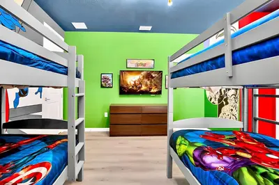 a bedroom with two bunk beds and a green wall at Upstay-Mansion w Spa-Pool-Cinema-Games - Sleeps 36 in Kissimmee