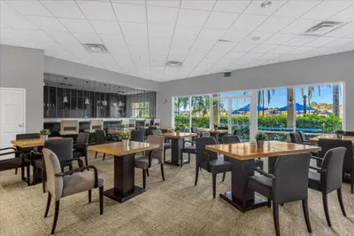 a dining room with tables and chairs and windows at 3 Bed 2,5 Bath Perfect Family home Bunk Beds townhouse in Kissimmee