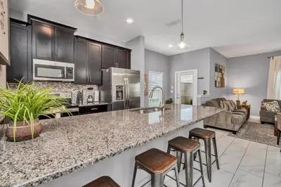 a kitchen with a large counter and stools at 3097Pequod townhouse in Kissimmee