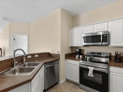 a kitchen with a sink and a stove and a microwave at Oakwater Retreat condo in Orlando
