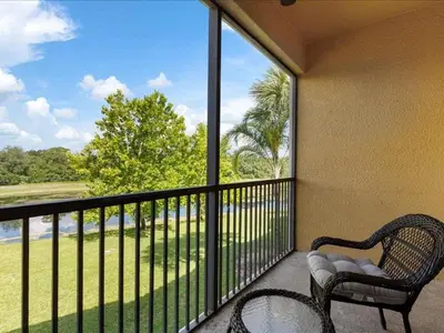 a balcony with a chair and a table and a window at Oakwater Retreat condo in Orlando