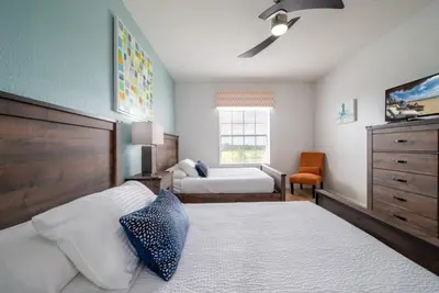 a bedroom with two beds and a dresser at Your Vista Cay Lakeview Allure condo in Orlando