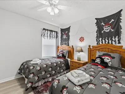 a bedroom with two beds with skulls and a ceiling fan at Treasure Hunt Retreat home in Kissimmee