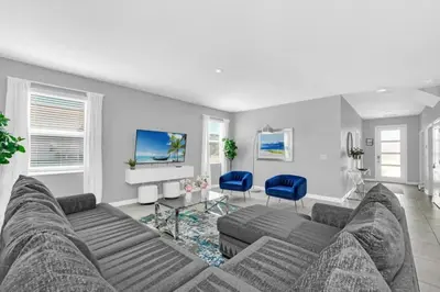 a living room with a couch and blue chairs at Storey Lake 6 bed Home- King Master on 1st Floor villa in Kissimmee