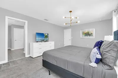 a bedroom with a bed and a flat screen tv at Storey Lake 6 bed Home- King Master on 1st Floor villa in Kissimmee