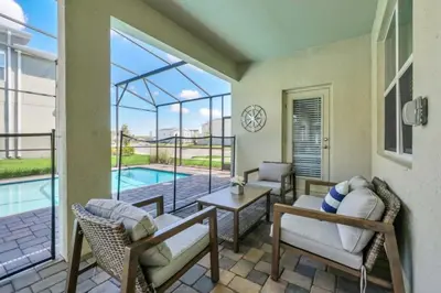 a living room with chairs and a table and a pool at Storey Lake 6 bed Home- King Master on 1st Floor villa in Kissimmee