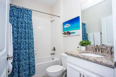 a bathroom with a toilet and a sink and a tub at Storey Lake Pool Home with Resort Amenities near DISNEY in Kissimmee