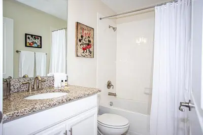 a bathroom with a sink and a toilet and a tub at Storey Lake Pool Home with Resort Amenities near DISNEY in Kissimmee