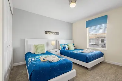 a bedroom with two beds and a window at 4978 Luxurious 4BR Sunshine Getaway at Storey Lake in Kissimmee