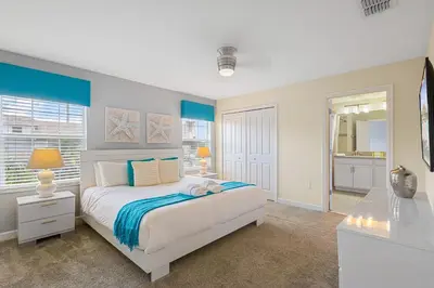 a bedroom with a large bed and a bathroom at 4978 Luxurious 4BR Sunshine Getaway at Storey Lake in Kissimmee
