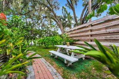 a white picnic table next to a wooden bench at Spring-Fed Lake King Suite Pet Friendly in Orlando