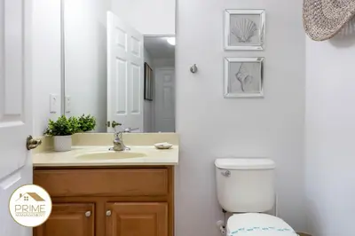 a bathroom with a sink and a toilet and a mirror at Amazing 6bd Resort Home Pool & Near Disney in Kissimmee
