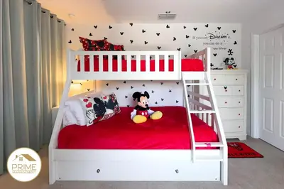 a bedroom with a bunk bed with a red bedspread at Amazing 6bd Resort Home Pool & Near Disney in Kissimmee